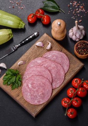 Slices of delicious fresh sausage on a wooden cutting board chicken-salami